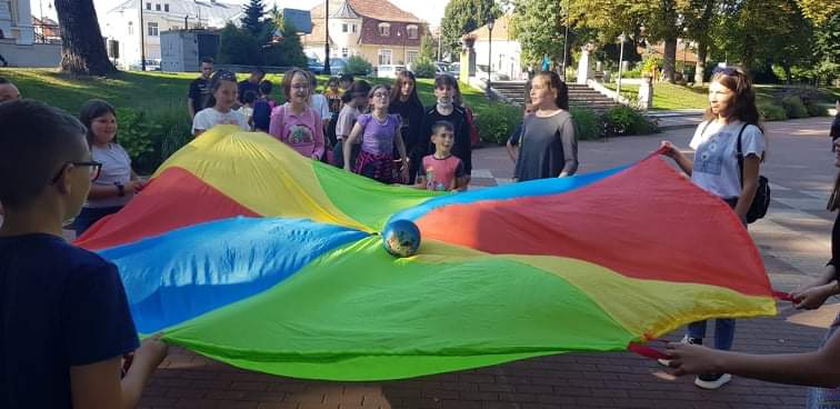 Elevi jucându-se cu parașuta colorată în parc, la Fun Days Erasmus